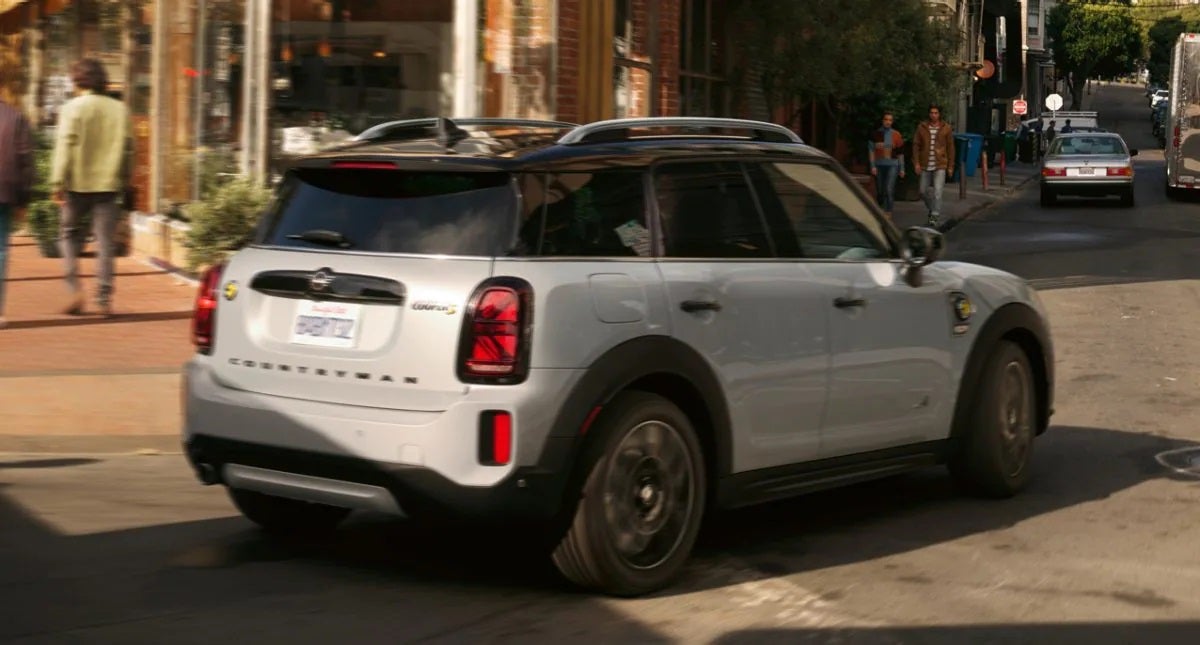 The MINI Cooper SE Countryman PHEV turning a corner in the city. MINI of Rochester in Rochester NY