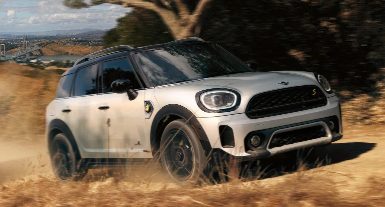 The MINI Cooper SE Countryman PHEV driving on dirt terrain. MINI of Rochester in Rochester NY