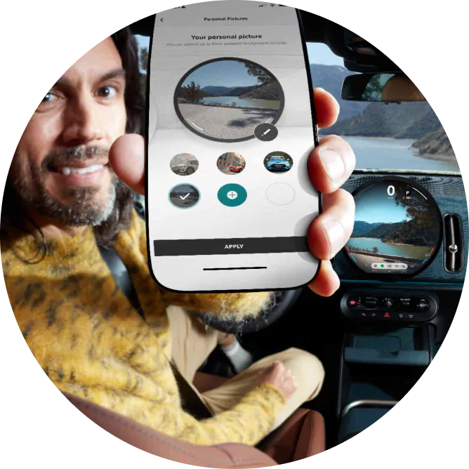 A man holding up his phone with the MINI App open on the screen.