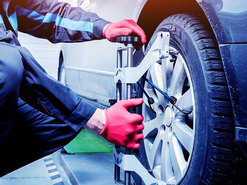 Technician repairing a car wheel in a workshop